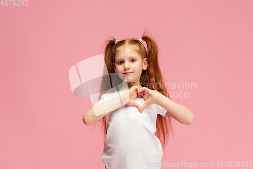 Image of Happy caucasian little girl isolated on pink studio background. Looks happy, cheerful, sincere. Copyspace. Childhood, education, emotions concept