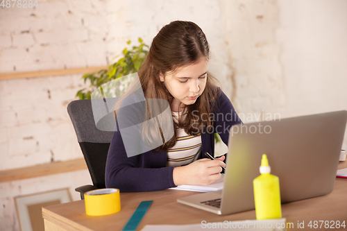 Image of Little girl studying by group video call, use video conference with teacher, listening to online course