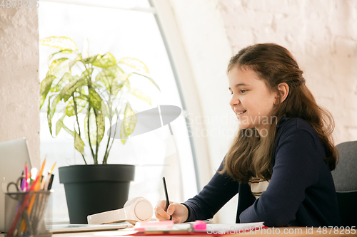 Image of Little girl studying by group video call, use video conference with teacher, listening to online course