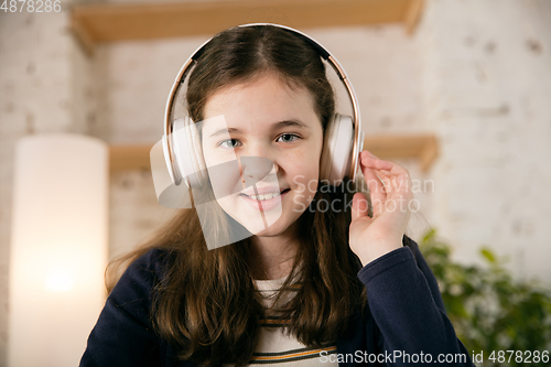 Image of Little girl wearing headphones during online education course, lesson, view of screen