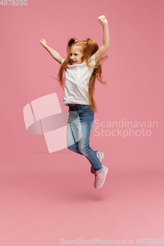 Image of Happy caucasian little girl isolated on pink studio background. Looks happy, cheerful, sincere. Copyspace. Childhood, education, emotions concept