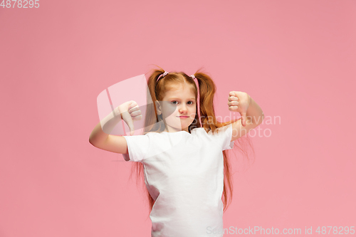 Image of Happy caucasian little girl isolated on pink studio background. Looks happy, cheerful, sincere. Copyspace. Childhood, education, emotions concept