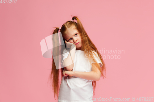 Image of Happy caucasian little girl isolated on pink studio background. Looks happy, cheerful, sincere. Copyspace. Childhood, education, emotions concept