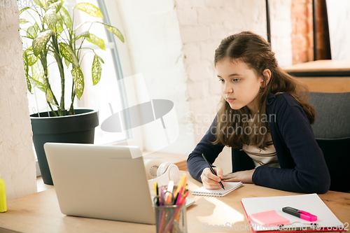 Image of Little girl studying by group video call, use video conference with teacher, listening to online course