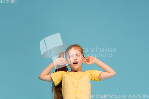 Image of Happy caucasian little girl isolated on blue studio background. Looks happy, cheerful, sincere. Copyspace. Childhood, education, emotions concept