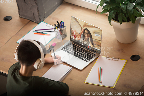 Image of Little boy studying by group video call, use video conference with teacher, listening to online course