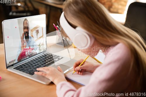 Image of Little girl studying by group video call, use video conference with teacher, listening to online course