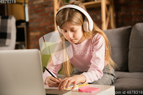 Image of Little girl studying by group video call, use video conference with teacher, listening to online course