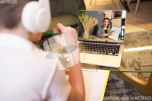 Image of Little boy studying by group video call, use video conference with teacher, listening to online course