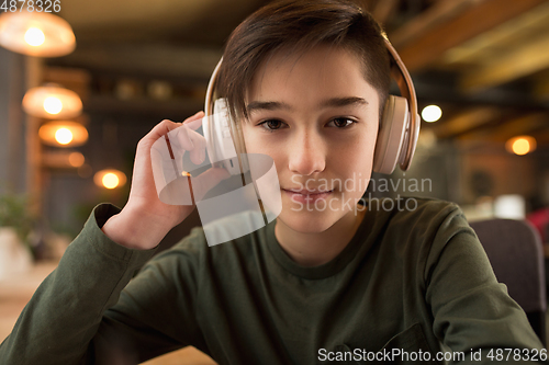 Image of Little boy wearing headphones during online education course, lesson, view of screen