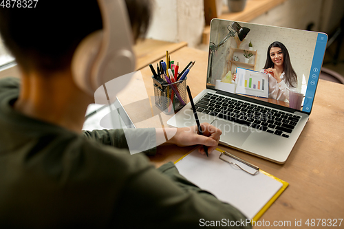 Image of Little boy studying by group video call, use video conference with teacher, listening to online course