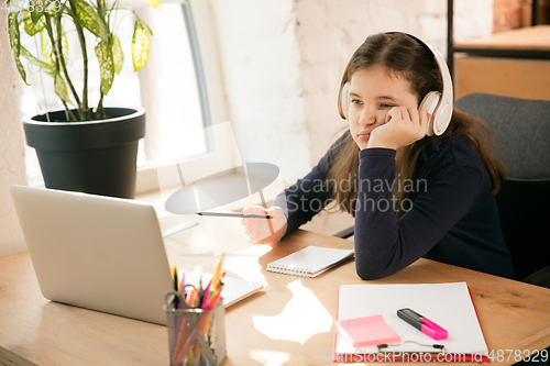 Image of Little girl studying by group video call, use video conference with teacher, listening to online course