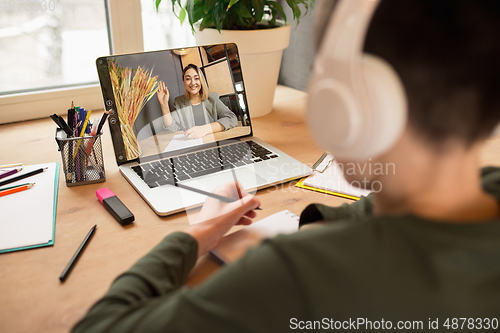 Image of Little boy studying by group video call, use video conference with teacher, listening to online course