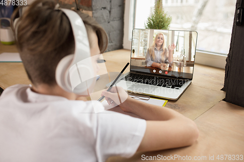 Image of Little boy studying by group video call, use video conference with teacher, listening to online course