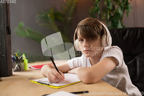 Image of Little boy studying by group video call, use video conference with teacher, listening to online course