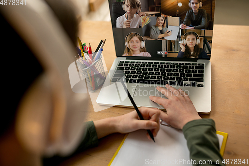 Image of Little boy studying by group video call, use video conference with teacher, listening to online course