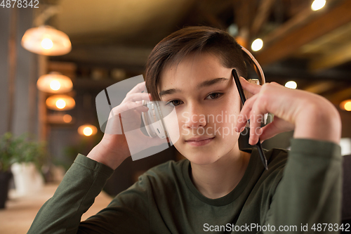 Image of Little boy wearing headphones during online education course, lesson, view of screen