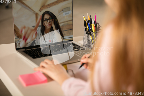 Image of Little girl studying by group video call, use video conference with teacher, listening to online course