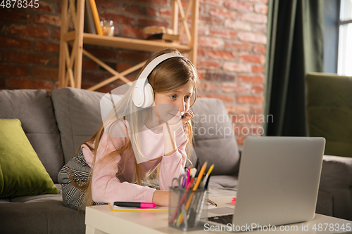 Image of Little girl studying by group video call, use video conference with teacher, listening to online course