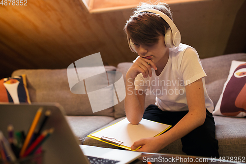 Image of Little boy studying by group video call, use video conference with teacher, listening to online course