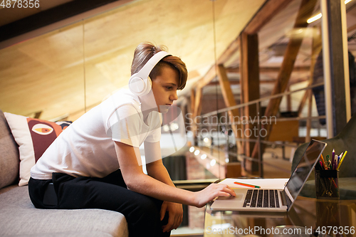 Image of Little boy studying by group video call, use video conference with teacher, listening to online course