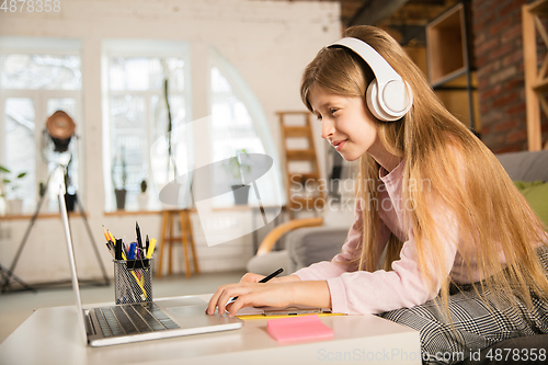 Image of Little girl studying by group video call, use video conference with teacher, listening to online course