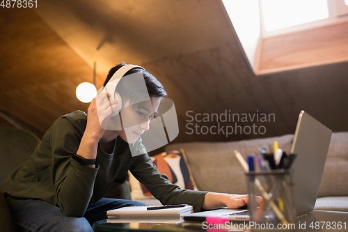 Image of Little boy studying by group video call, use video conference with teacher, listening to online course