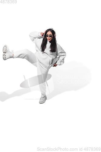 Image of High angle view of young woman on white studio background. Girl in motion or movement. Human emotions and facial expressions concept