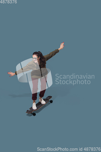 Image of High angle view of young woman on blue studio background. Girl in motion or movement. Human emotions and facial expressions concept
