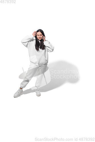Image of High angle view of young woman on white studio background. Girl in motion or movement. Human emotions and facial expressions concept