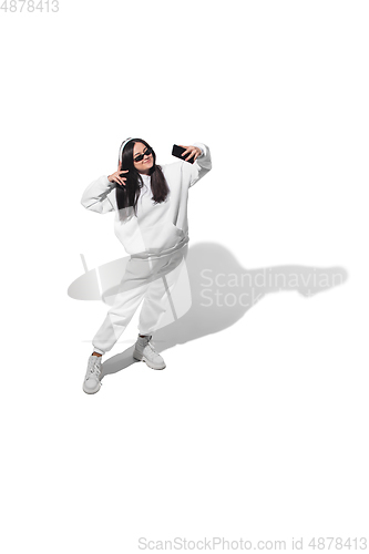 Image of High angle view of young woman on white studio background. Girl in motion or movement. Human emotions and facial expressions concept