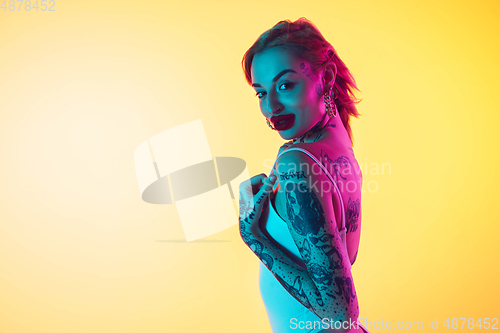 Image of Portrait of young caucasian woman on gradient yellow background with copyspace, unusual and freaky appearance
