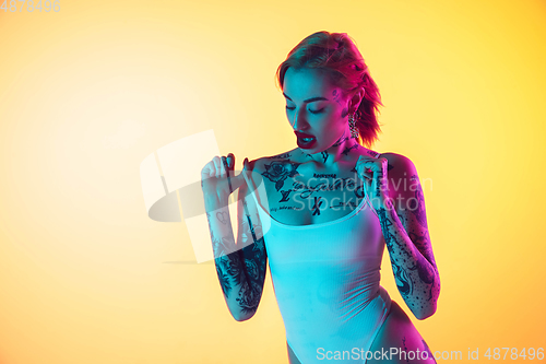 Image of Portrait of young caucasian woman on gradient yellow background with copyspace, unusual and freaky appearance