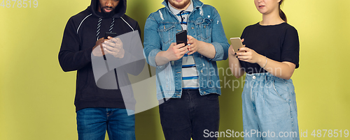 Image of Group of friends using mobile smartphones. Teenagers addiction to new technology trends. Close up.