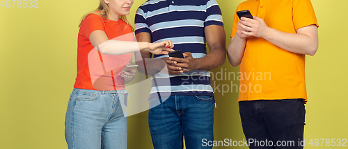 Image of Group of friends using mobile smartphones. Teenagers addiction to new technology trends. Close up.