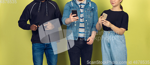 Image of Group of friends using mobile smartphones. Teenagers addiction to new technology trends. Close up.