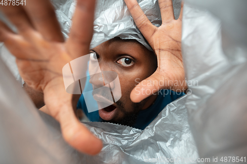 Image of African-american man looking for job in unusual places at his home