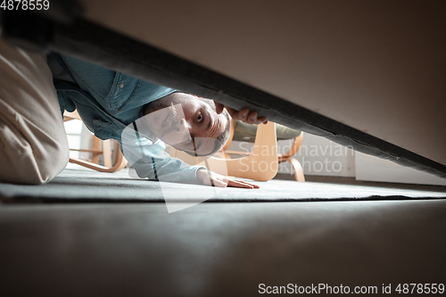 Image of Caucasian man looking for job in unusual places at his home