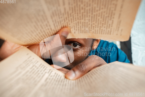 Image of African-american man looking for job in unusual places at his home