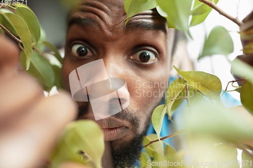 Image of African-american man looking for job in unusual places at his home