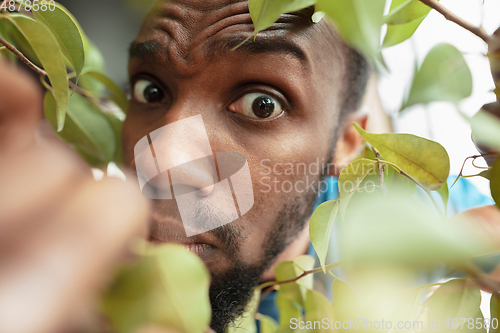 Image of African-american man looking for job in unusual places at his home