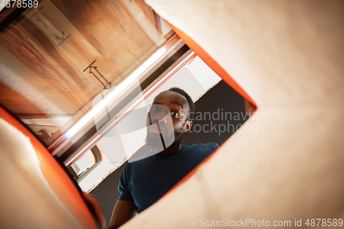 Image of African-american man looking for job in unusual places at his home