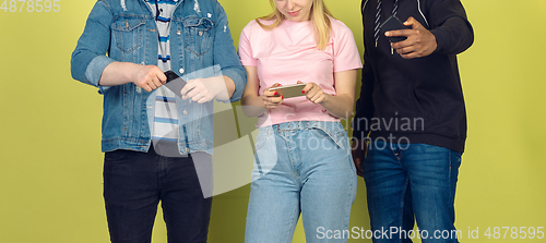 Image of Group of friends using mobile smartphones. Teenagers addiction to new technology trends. Close up.