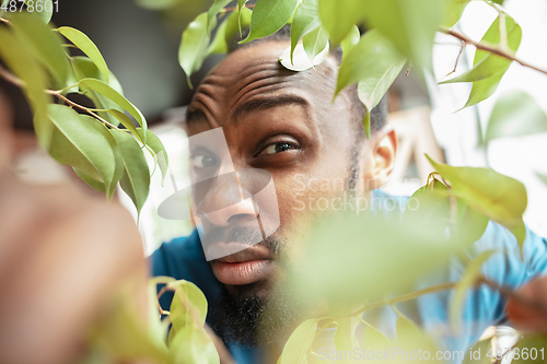 Image of African-american man looking for job in unusual places at his home