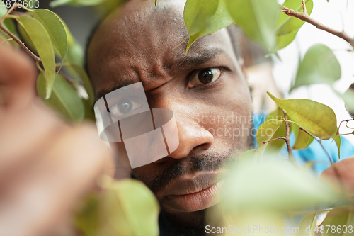 Image of African-american man looking for job in unusual places at his home