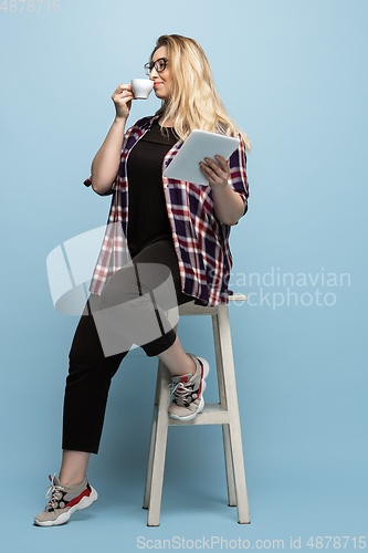 Image of Young caucasian woman in casual wear on blue background. Bodypositive female character, plus size businesswoman