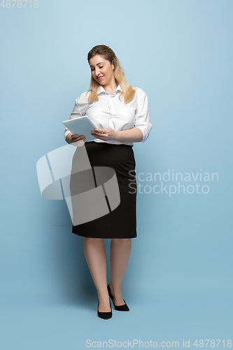 Image of Young caucasian woman in office attire on blue background. Bodypositive female character. plus size businesswoman