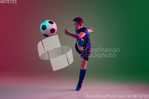 Image of Teen male football or soccer player, boy on gradient background in neon light - motion, action, activity concept