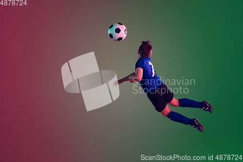 Image of Teen male football or soccer player, boy on gradient background in neon light - motion, action, activity concept