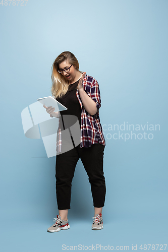 Image of Young caucasian woman in casual wear on blue background. Bodypositive female character, plus size businesswoman